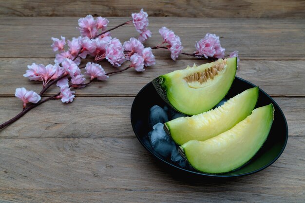 melon tranché avec de la glace sur fond de bois