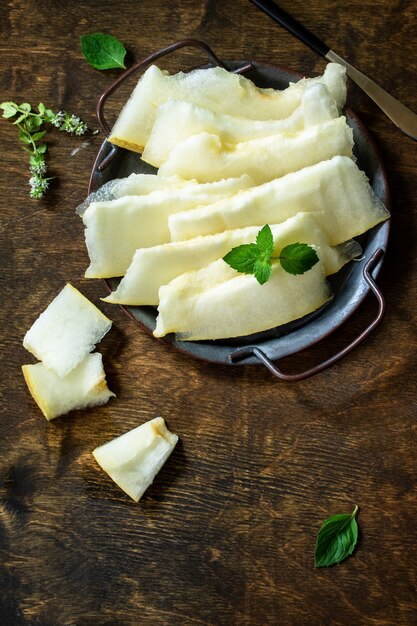 Melons frais coupés en morceaux sur une table en bois rustique