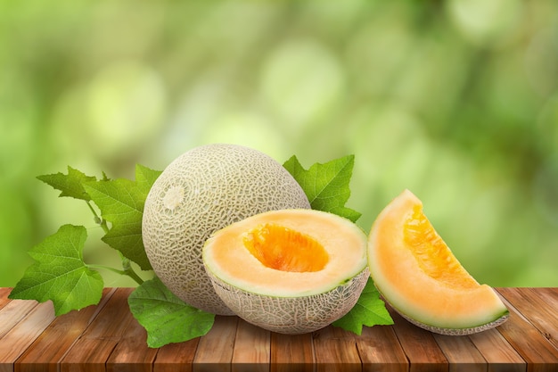 Melons de miellat sur table en bois sur vert