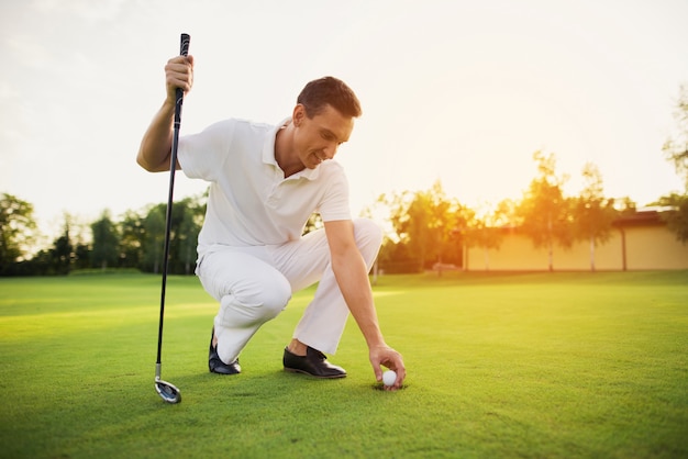 Un Membre Du Club De Golf Joue Sur Un Parcours Au Coucher Du Soleil.