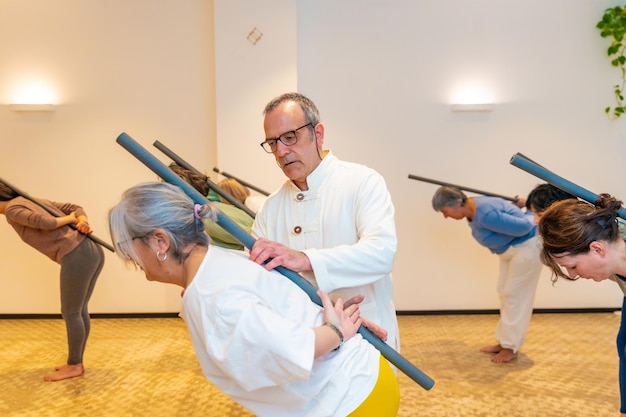 Les membres de la classe de Qi gong utilisent un tube pour étirer le dos