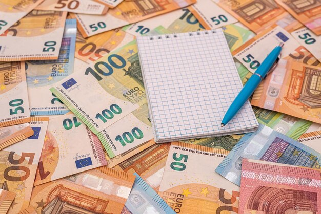 Mémo de bloc-notes vide avec un stylo sur le concept d'économie d'argent en euros