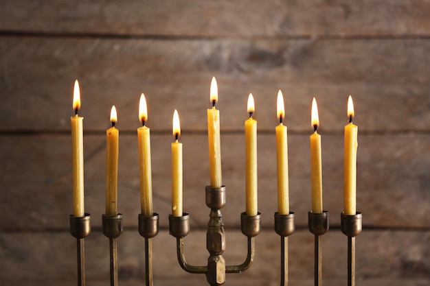 Menorah avec bougies pour Hanukkah sur fond bois flou gros plan
