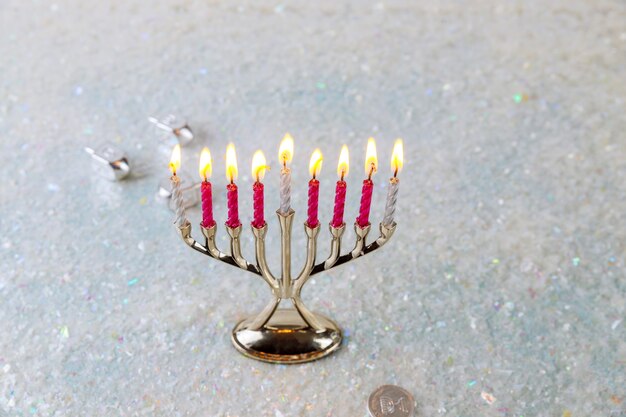 Menorah chandelier juif avec des bougies allumées sur fond d'éclat. Vacances de Hanoukka.