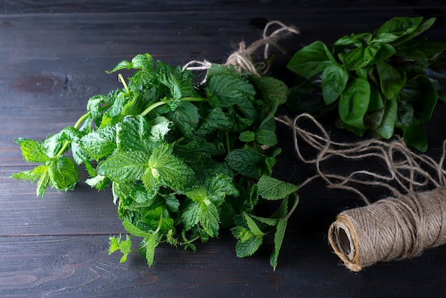 Menthe fraîche laisse des herbes sur une table sombre.