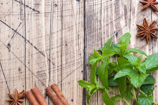 Photo menthe fraîche verte, épices cannelle et anis sur table en bois