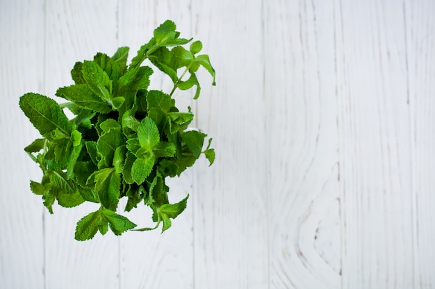 Photo menthe poivrée fraîche dans un verre sur fond clair