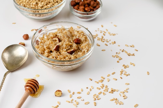 Menu diététique équilibré pour le petit-déjeuner avec un bol de porridge à l&#39;avoine aux noisettes et au miel