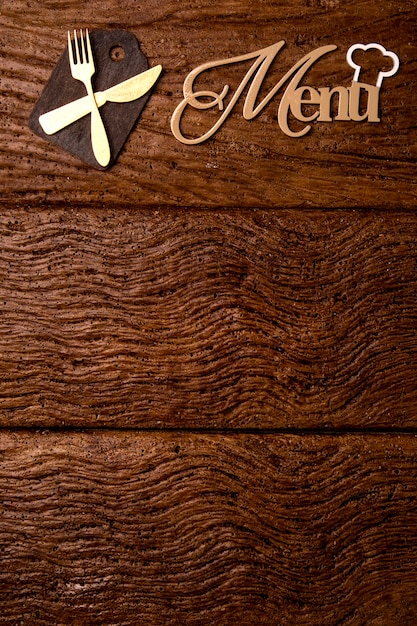 Le menu du restaurant. Vue de dessus du menu de planche de bois portant sur le bureau en bois rustique avec accessoires.