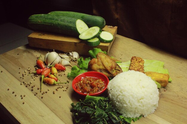 Photo le menu de poulet est complété par du tempeh au sauce chili et des légumes frais.