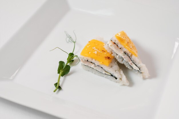 Menu sushi cuisine japonaise décorée de verdure sur plaque blanche