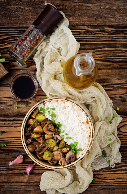 Menu végétalien. Aliments diététiques. Riz bouilli aux champignons et choux de Bruxelles à la mode asiatique. Vue de dessus. Mise à plat.