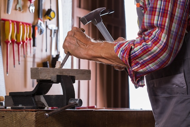 Menuiserie, concept de fabrication de meubles, outils de menuiserie. Homme supérieur, menuisier travaillant sur l'établi.