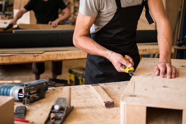 Menuisier fabriquant des meubles en bois en atelier