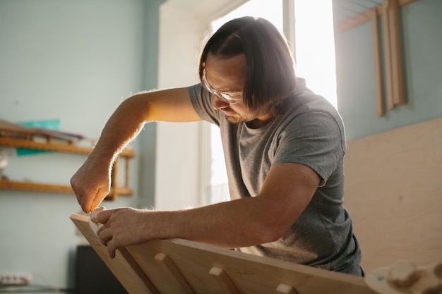 Un menuisier fabrique un kit d'escalade Montessori pour les enfants dans son atelier