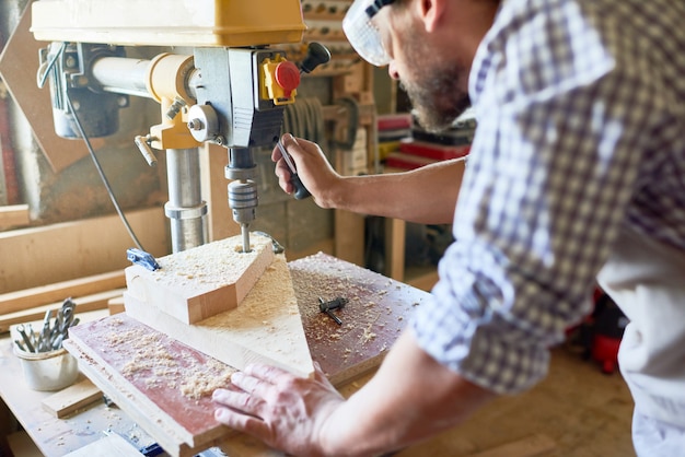 Menuisier mature travaillant dans la menuiserie