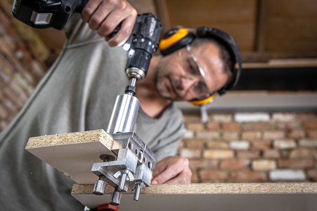 Menuisier professionnel travaillant avec du bois et des outils de construction dans la maison.