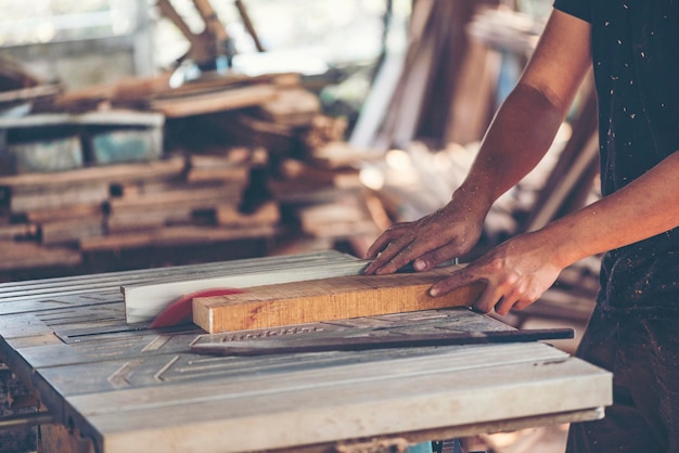 Un menuisier qui coupe du bois dans un atelier