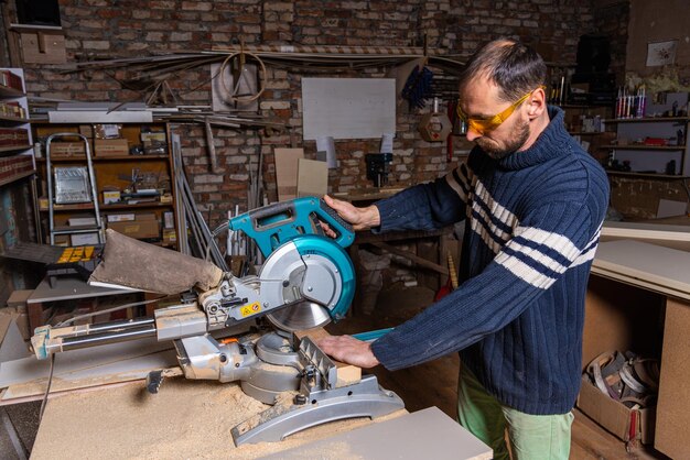 Un menuisier travaille dans un atelier de fabrication de meubles