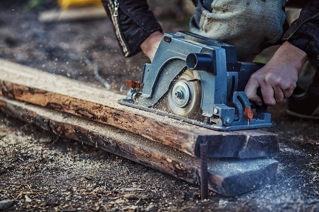 Menuisier utilisant une scie circulaire pour le bois. Fermer