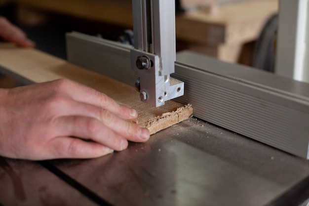 Un menuisier vêtu d'une chemise à carreaux travaille à une machine dans un atelier. Bois. Compatibilité écologique. Mode de vie. Fermer. photo de haute qualité