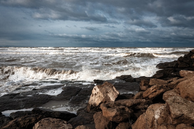 Mer agitée, les vagues se brisent sur les rochers