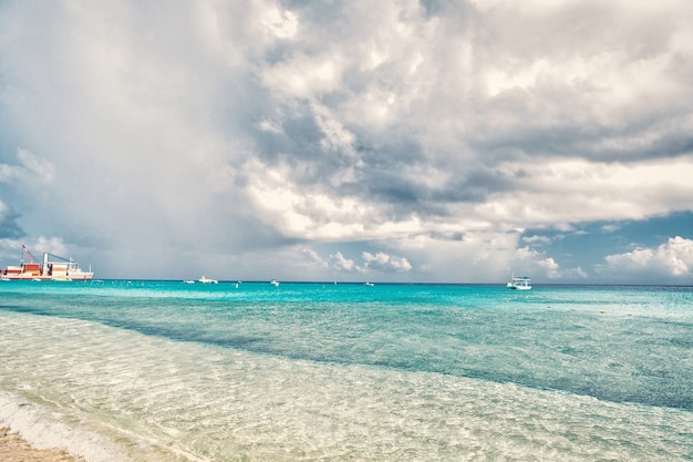 Mer avec bateaux et port dans les îles grand turc, turcs et caïques. Paysage marin aux eaux turquoises sur ciel nuageux. Vacances d'été sur l'île tropicale. Découverte, aventure et envie de voyager.