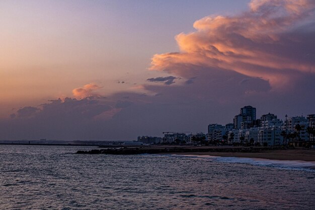 La mer et les bâtiments contre le ciel au coucher du soleil