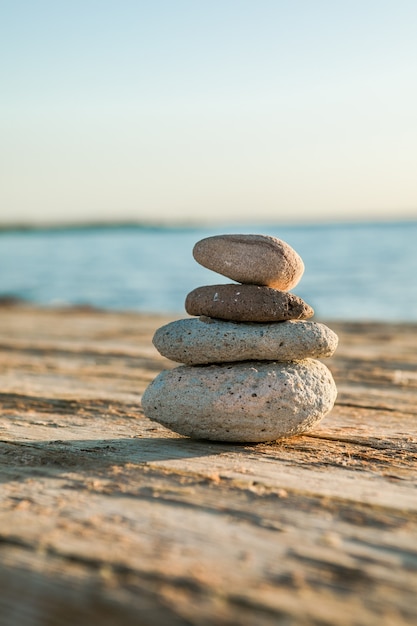 Mer bleue sur la surface Mise au point sélective, pierres zen sur la plage de la mer, méditation, spa, harmonie, calme, concept d'équilibre