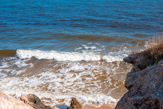 La mer bleue avec des vagues sur une côte rocheuse La rive de la mer d'Azov en Crimée