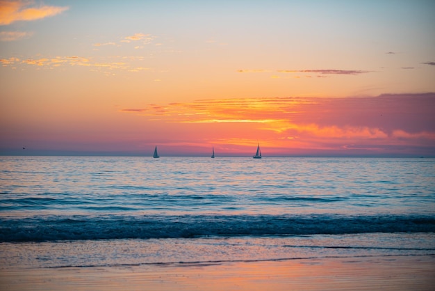 Mer calme avec ciel coucher de soleil et soleil à travers les nuages sur l'océan et le paysage marin de fond de ciel