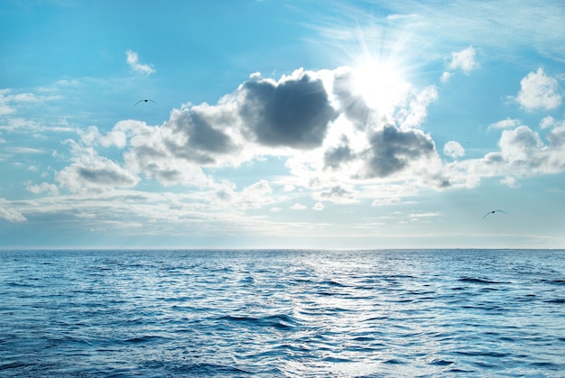 Mer avec eau bleue, ciel et nuages