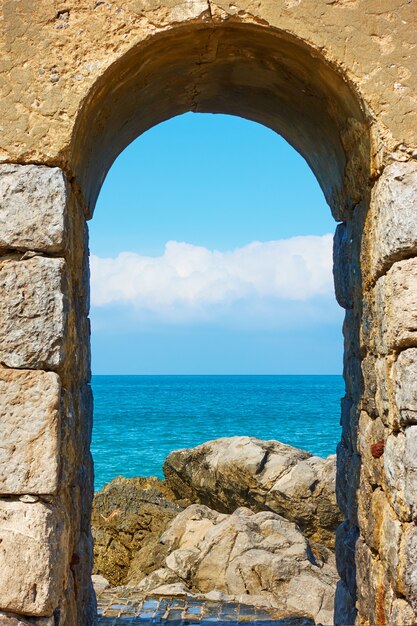 Photo mer méditerranée et côte rocheuse par arch à cefalu, sicile, italie