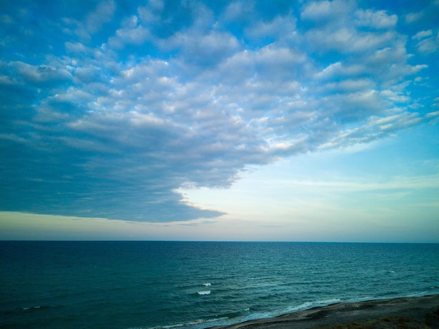 Mer Noire et plage à proximité contre un ciel avec des nuages et un soleil à l'aube