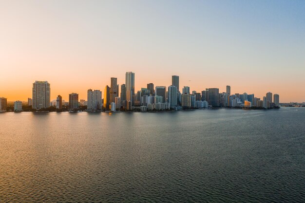 Mer par des bâtiments contre un ciel clair au coucher du soleil