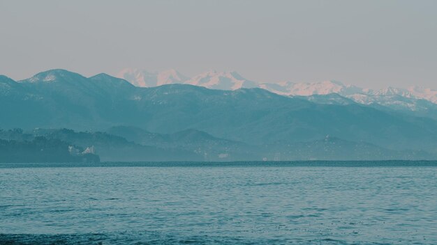 Mer par des montagnes couvertes de neige contre un ciel clair par une journée ensoleillée près de la ville de Kobuleti Adjara en Géorgie