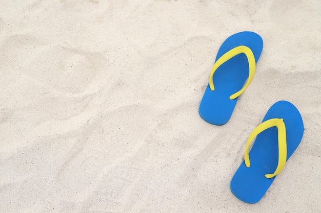 Mer sur la plage Empreinte de personnes sur le sable et pantoufle de pieds en sandales chaussures sur fond de sable de plage voyage vacances concept