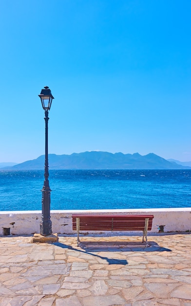 Mer et seaftont avec banc et lampadaire vintage ion journée ensoleillée d'été, Grèce - Paysage vertical, paysage marin