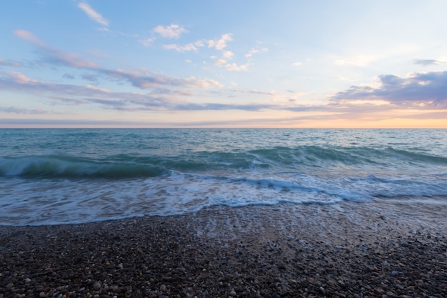 Mer surf sur une plage pierreuse.