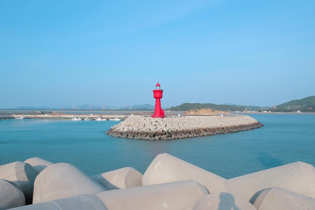 La mer avec un tétraport et un phare rouge