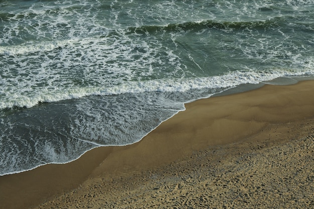 Mer avec des vagues sur une belle plage de sable