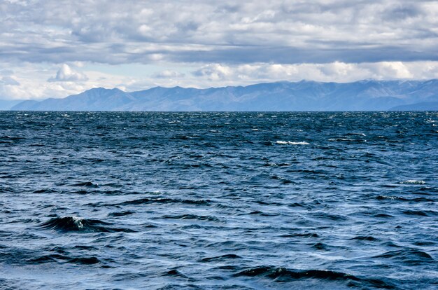 Mer avec vagues et ciel bleu nuageux