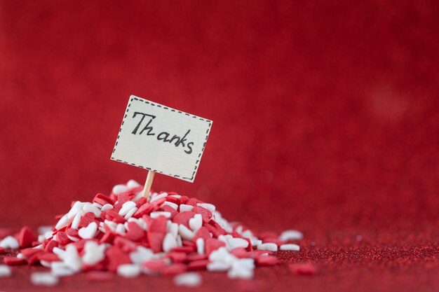 Merci texte composé à bord en tas de coeurs rouges et blancs sur le mur rouge pour la Saint-Valentin et le concept de jour de remerciement.