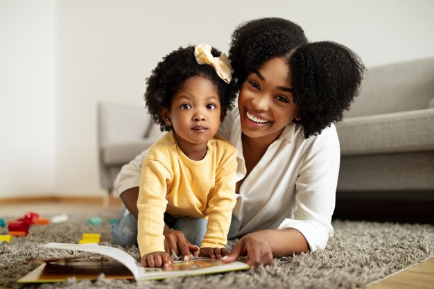 Photo une mère afro-américaine heureuse et sa petite fille jouant à la maison.