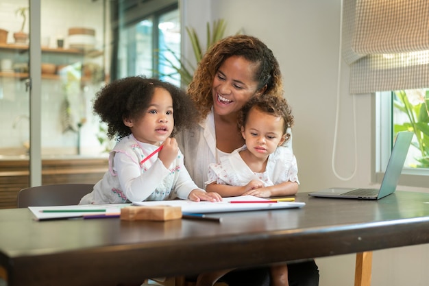Mère afro-américaine jouant avec ses filles à la maison
