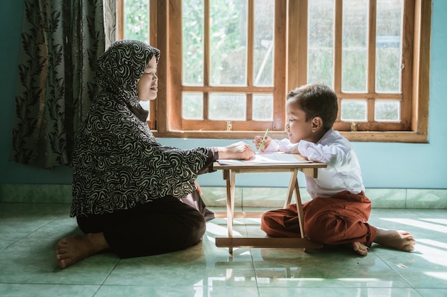 Mère aide son enfant à faire ses devoirs