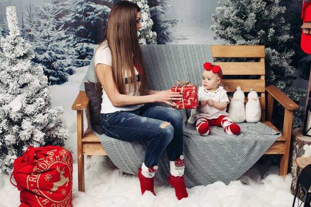 Mère aimante décorer un arbre de Noël avec bébé