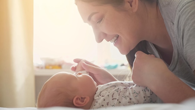 Une mère aimante embrasse les joues d'une petite fille se tenant la main