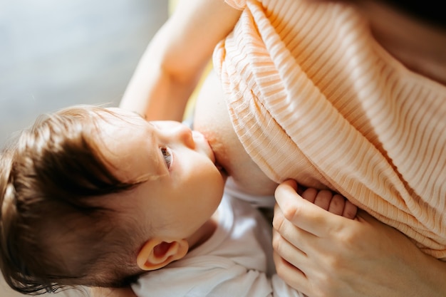 Mère allaitant bébé à la maison mère allaitante avec petit enfant jeune femme allaitant et nourrissant b...