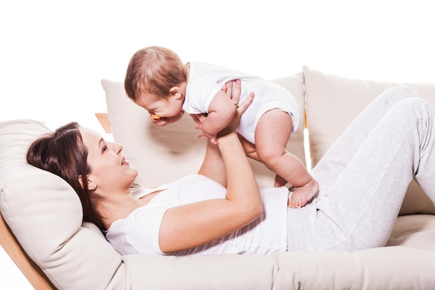 Mère allongée sur le canapé souriant à bébé